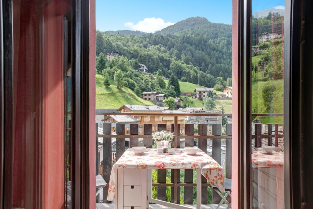 a table with a view of a mountain from a window at Appartamento Gaia in Caspoggio