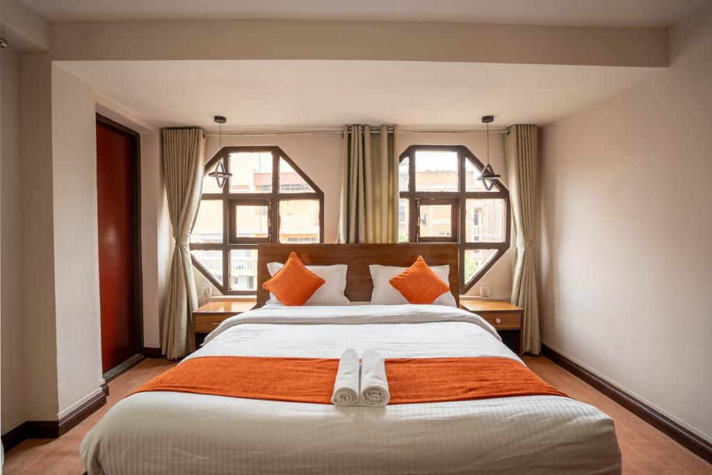 1 dormitorio con 1 cama grande y 2 ventanas en Hotel Pala, en Katmandú
