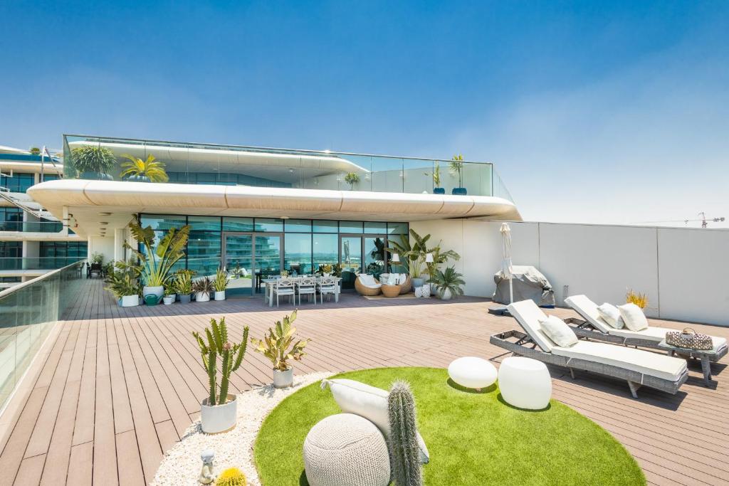 a large house with a deck with a patio at Voyage 5 Star Al Hadeel Sunset Sea View in Abu Dhabi