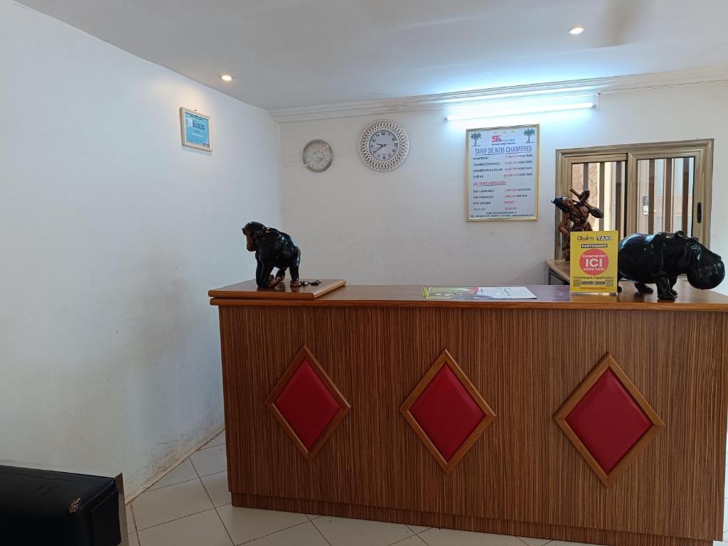 Deux statues de chiens assis au-dessus d'un comptoir dans l'établissement Sarada Hôtel, à Ouagadougou