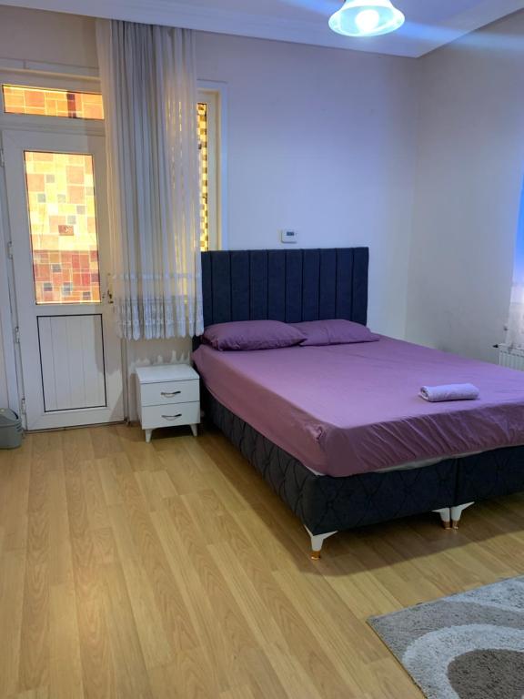 een slaapkamer met een groot bed met paarse lakens bij Apartment 3 bedrooms in Yalova