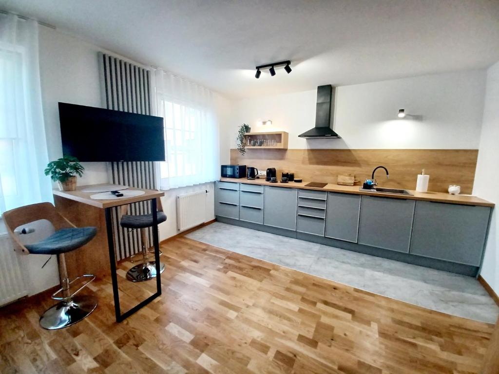 une grande cuisine avec une table et un évier dans l'établissement Kolory Warmii Apartamenty Garaż Podziemny-30pln-doba, à Olsztyn