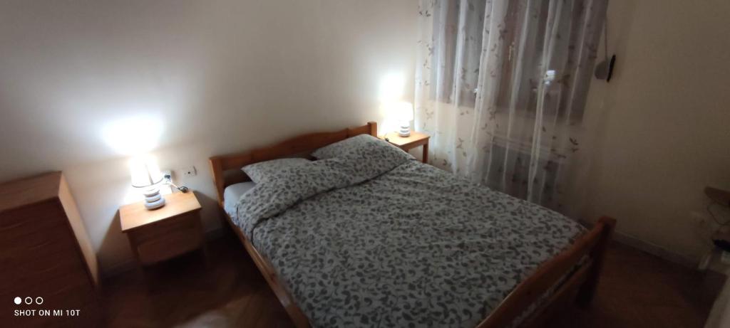 Appartement la scarpe في سانت أماند ليه أوكس: غرفة نوم مع سرير مع مصباحين على طاولتين