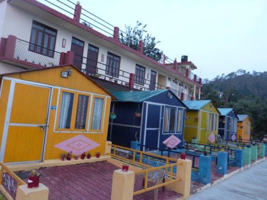 uma fila de casas coloridas no lado de um edifício em Himvadi Resorts Kausani em Kausani