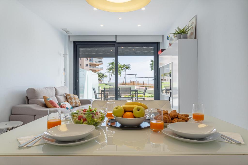 una mesa de comedor con un bol de fruta. en MyFlats Infinity View en Arenales del Sol