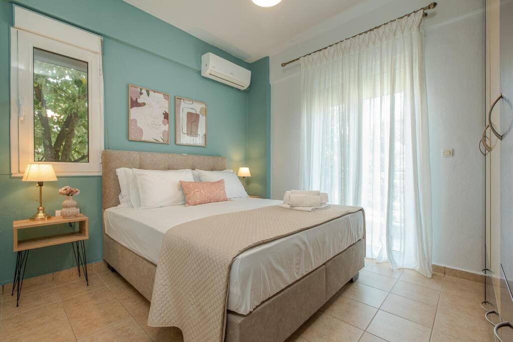Un dormitorio con una cama grande y una ventana en Tommy's Family Apartment, en Katerini