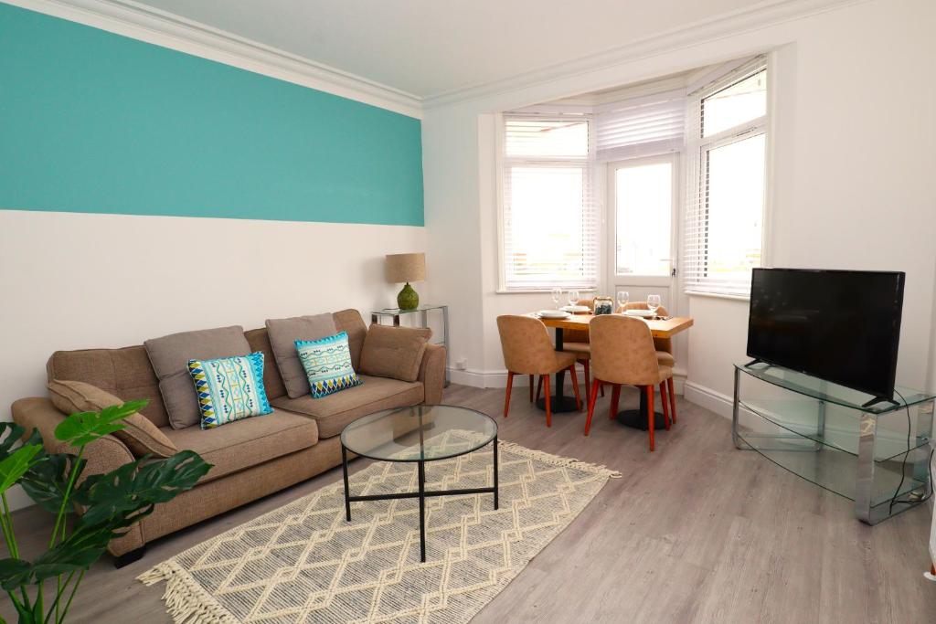 a living room with a couch and a table at Seafront House with balcony in Eastbourne