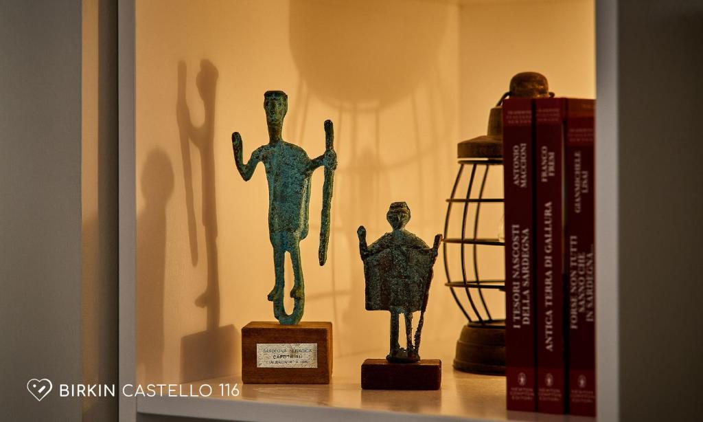 a shelf with a statue and books on it at Albergo Diffuso Birkin Castello in Cagliari