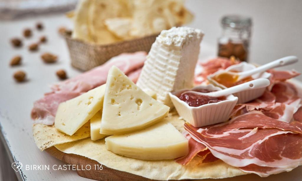 a plate of food with cheese meats and other foods at Albergo Diffuso Birkin Castello in Cagliari