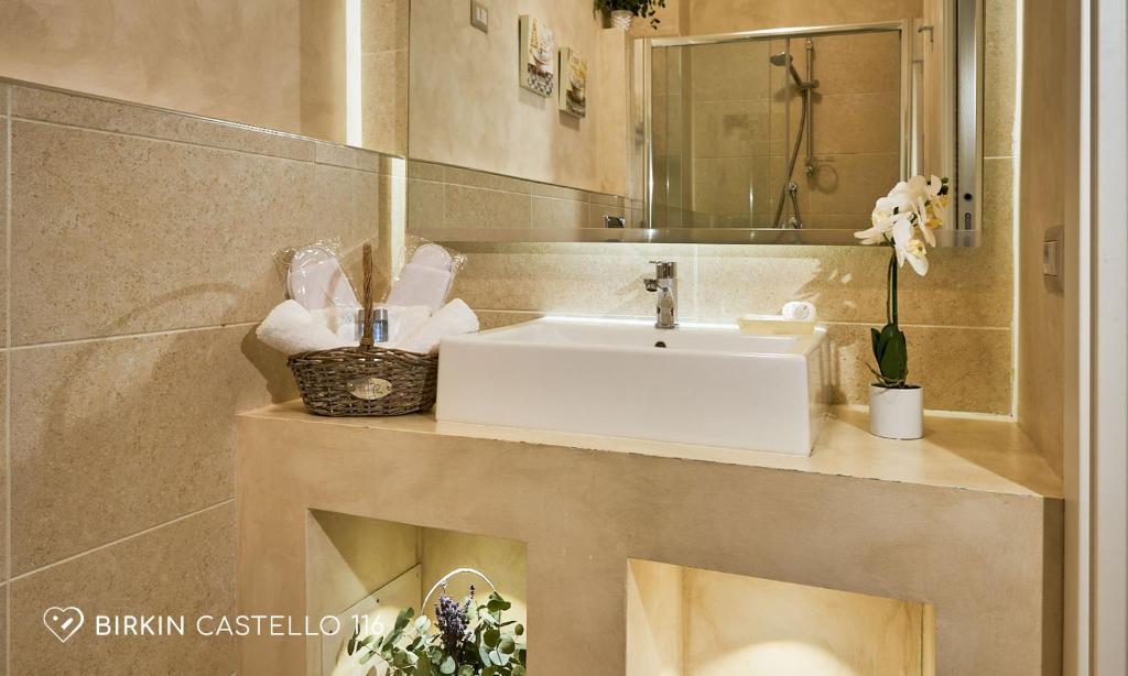 a bathroom with a white sink and a mirror at Albergo Diffuso Birkin Castello in Cagliari