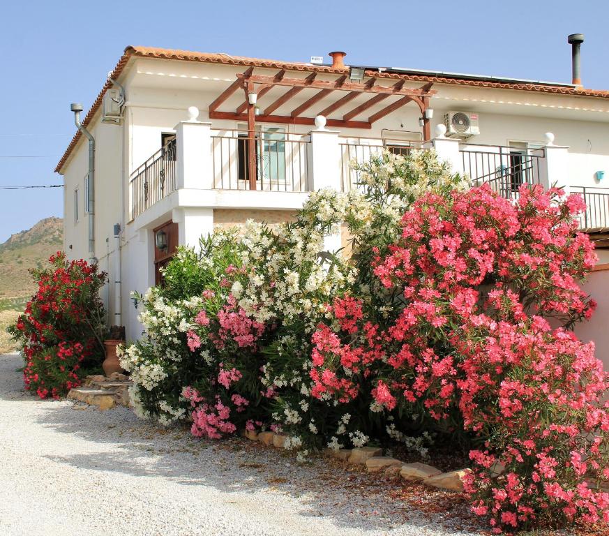 a building with pink and white flowers in front of it at Casa Nuestro Sueño in Oria