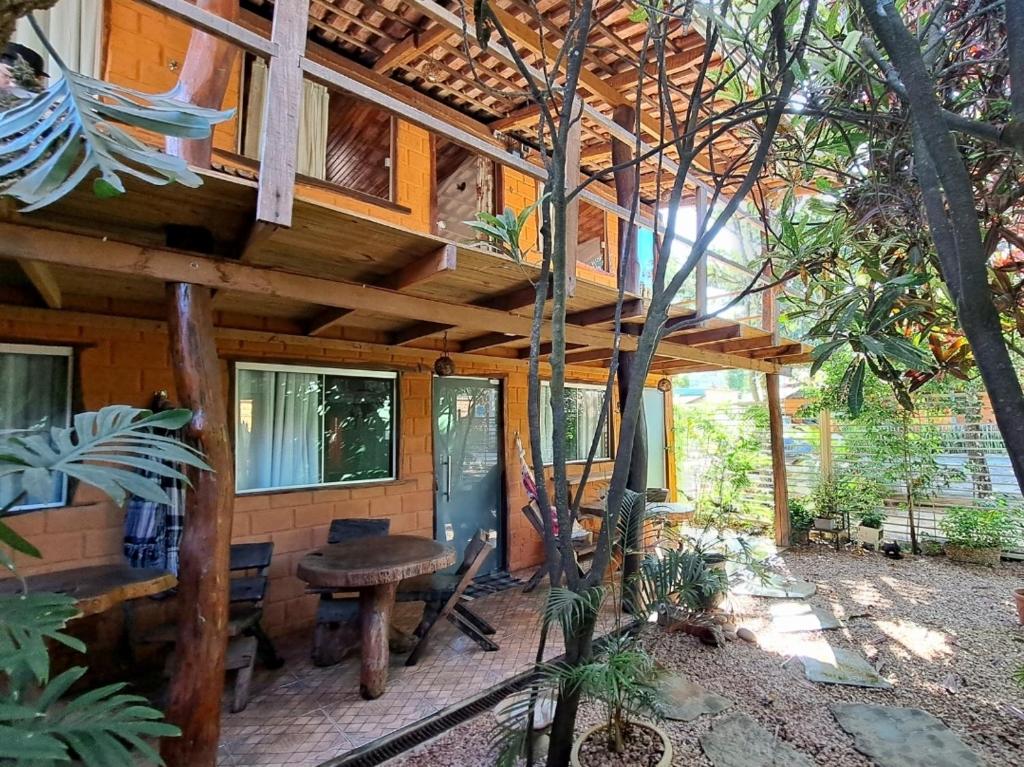 uma cabana na floresta com um telhado de madeira em Pousada Flor de Maio - Vila De São Jorge em Alto Paraíso de Goiás