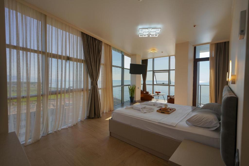 バトゥミにあるRUMI Hotelのベッドルーム(大きなベッド1台、大きな窓付)