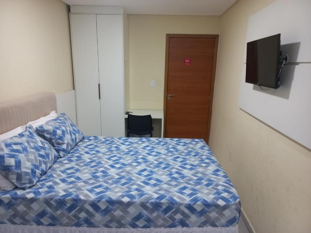 Schlafzimmer mit einem Bett und einem Flachbild-TV in der Unterkunft Hotel Kairos in Campina Grande