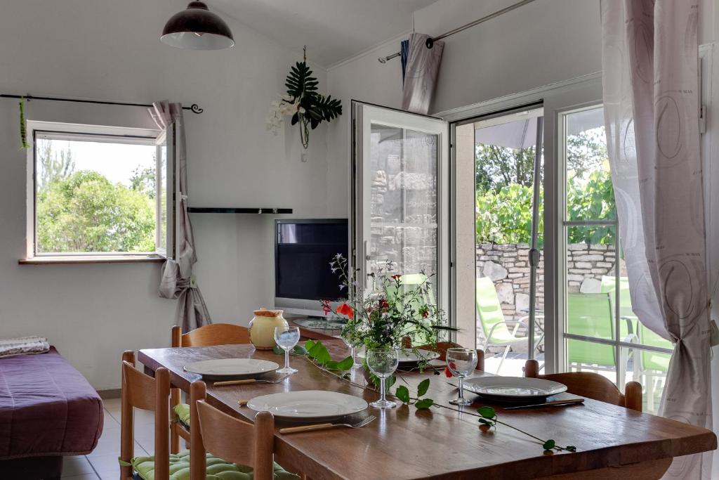 a dining room with a wooden table and chairs at Apartments La Vieille Source in Saint-Martin-dʼArdèche