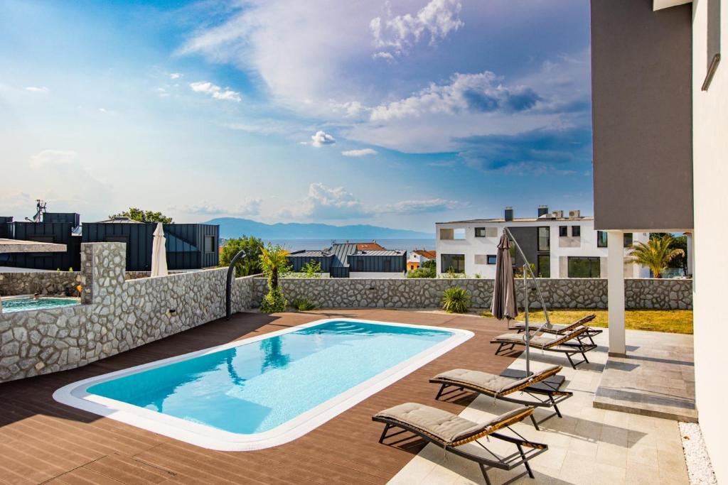 a swimming pool on the roof of a house at Apartments Aqua in Malinska