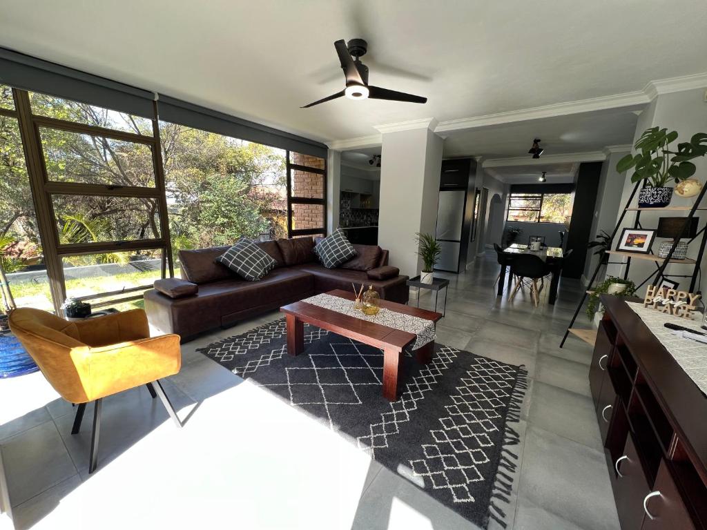 uma sala de estar com um sofá e uma mesa em Afrique134 Baobab Tree Private Family Garden Suite em Pretoria