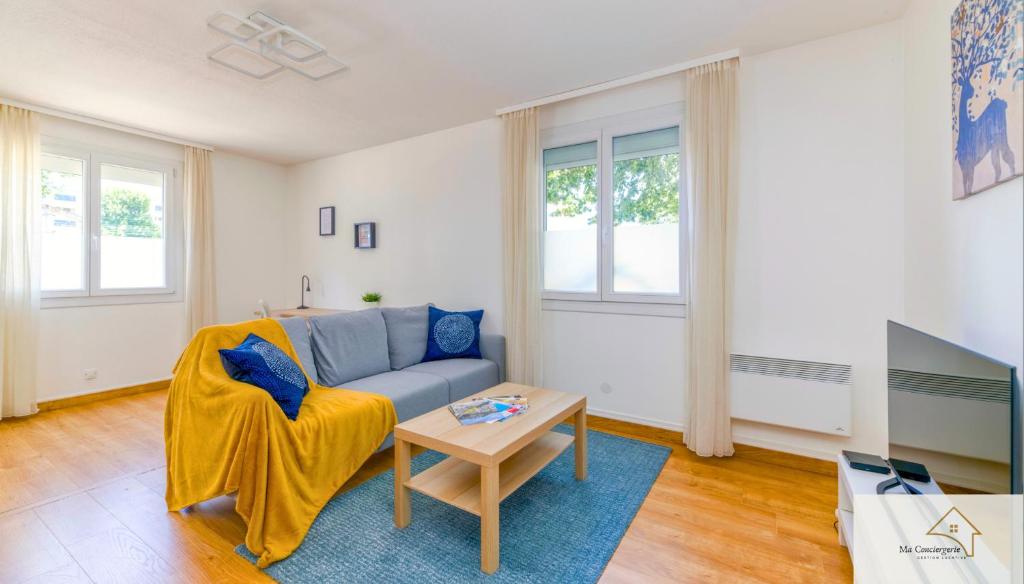 a living room with a couch and a table at Le Mykonos¶ Gare¶ 2Garages ¶Jardin ¶Spacieux in Grenoble