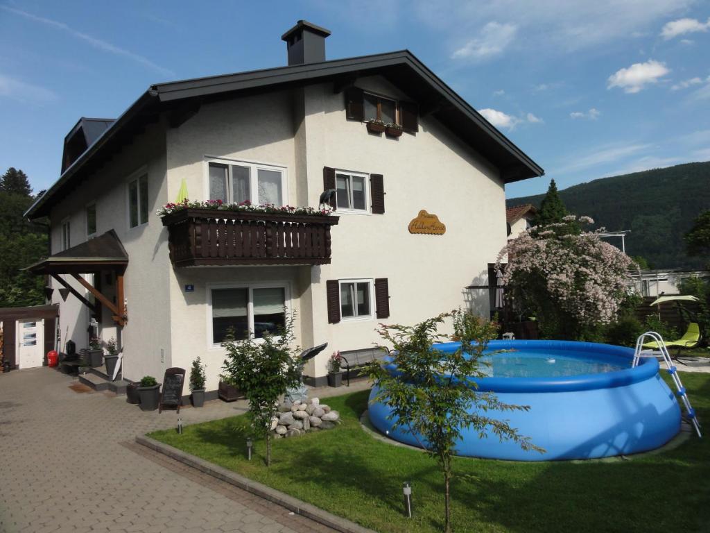 a house with a large tub in front of it at Pension AdlerHorst in Steindorf am Ossiacher See