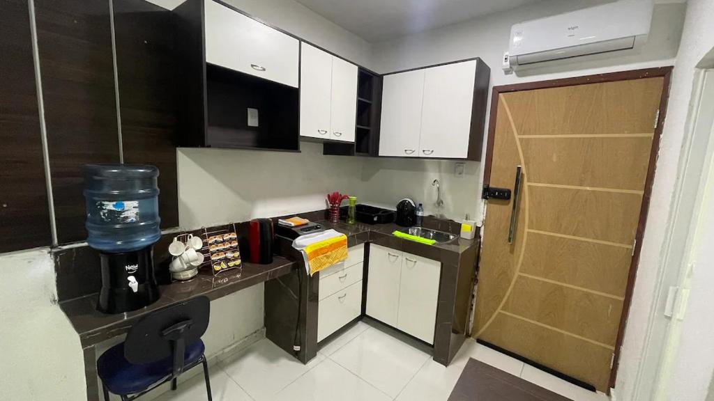 a small kitchen with white cabinets and a counter top at Studio Wifi Tv Ar-condicionado Orla Conforto in Petrolina
