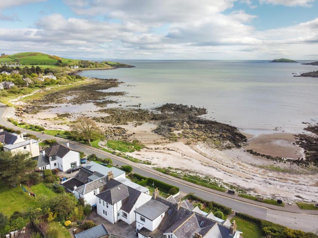 an aerial view of a beach with houses and the ocean at Neptune Cottage in Rockcliffe