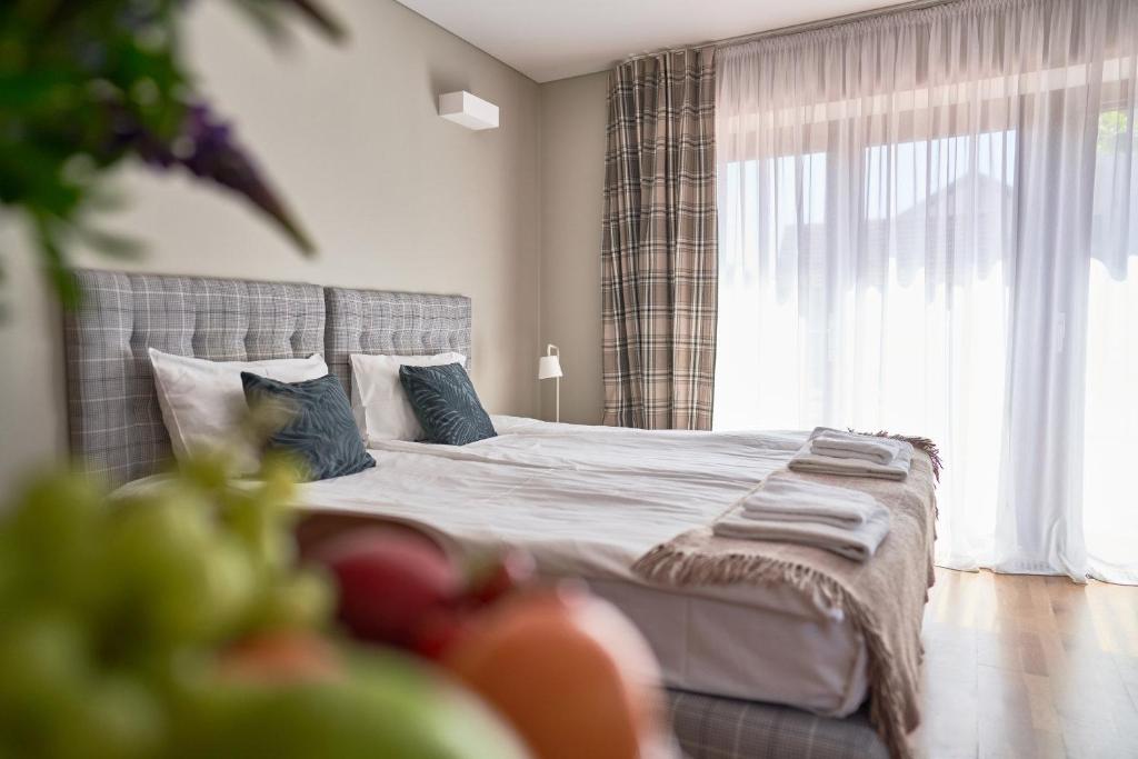 a bedroom with a bed and a large window at Palanga Visit Apartments and SPA in Palanga