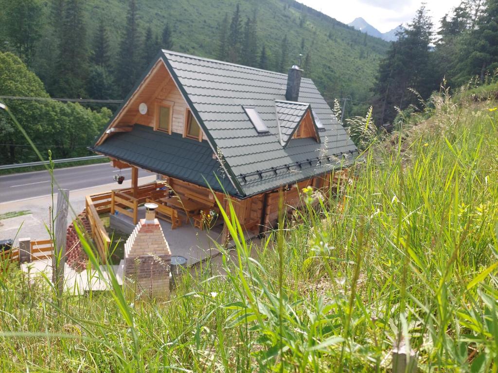 una casa con techo de metal en una montaña en Štýlový Zrub Martina B s pieckou a kúpacou kaďou!, en Ždiar