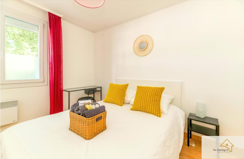 a bedroom with a white bed with yellow pillows and a window at Le Mykonos¶ Gare¶ 2Garages ¶Jardin ¶Spacieux in Grenoble
