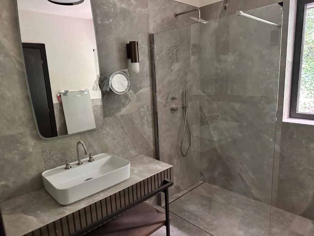 a bathroom with a sink and a shower at Maximilian Suites in Trieste