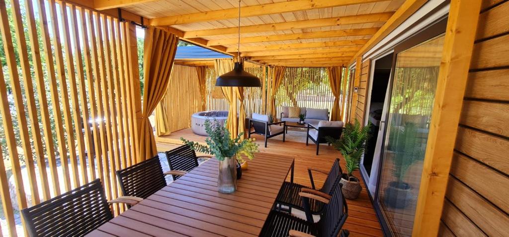 une terrasse couverte avec une table et des chaises en bois. dans l'établissement Mobile home Luka, à Kruševo