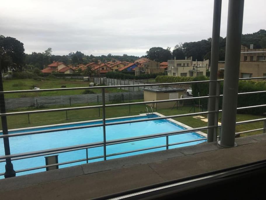 een balkon met uitzicht op een zwembad bij Apartamento ideal en urbanización con piscina in poo de Llanes