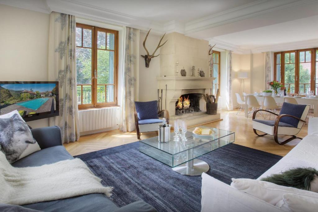 a living room with a couch and a glass table at Manoir de Leschaux - OVO Network in Le Petit-Bornand-lès-Glières