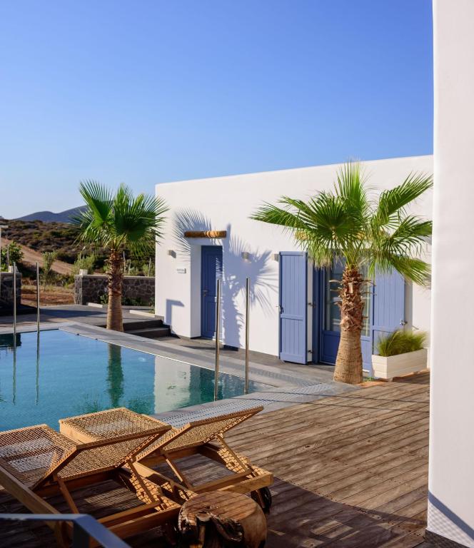 a villa with a swimming pool and palm trees at White Dream Suites Antiparos in Antiparos