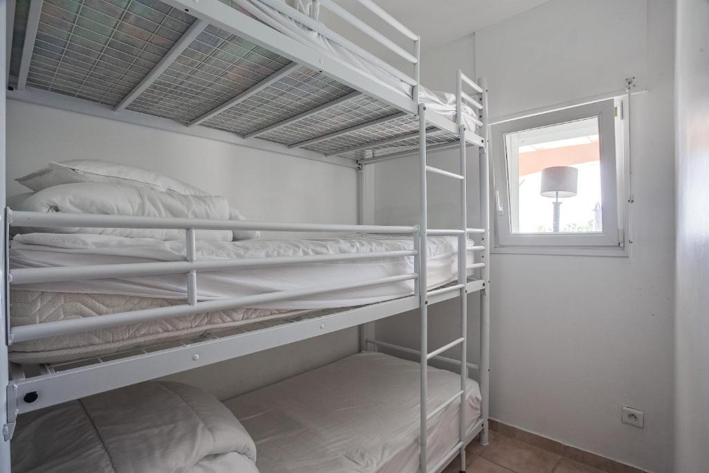 サン・マルタン・ダルデーシュにあるApartments La Vieille Sourceのベッドルーム1室(二段ベッド2台、窓付)が備わります。