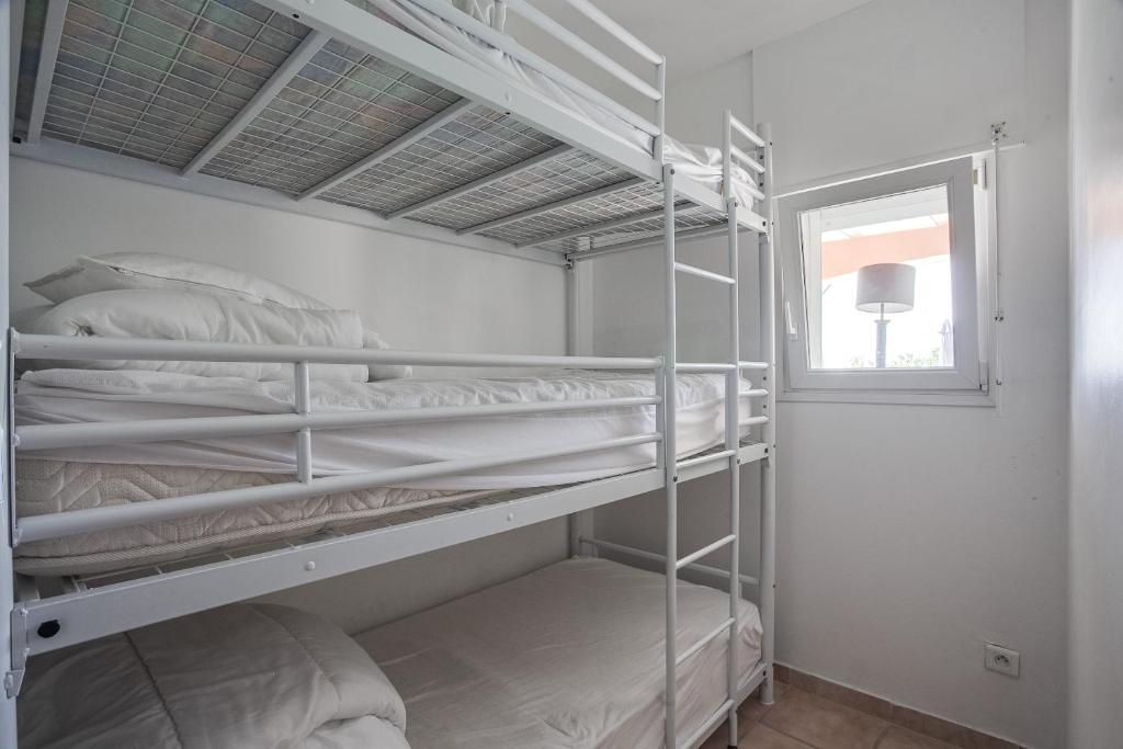 a bedroom with two bunk beds and a window at Apartments La Vieille Source in Saint-Martin-dʼArdèche