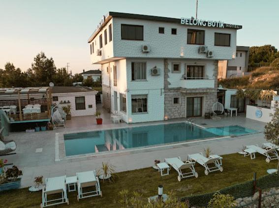 een groot gebouw met een zwembad voor een huis bij Belong Butik Otel in Çeşme