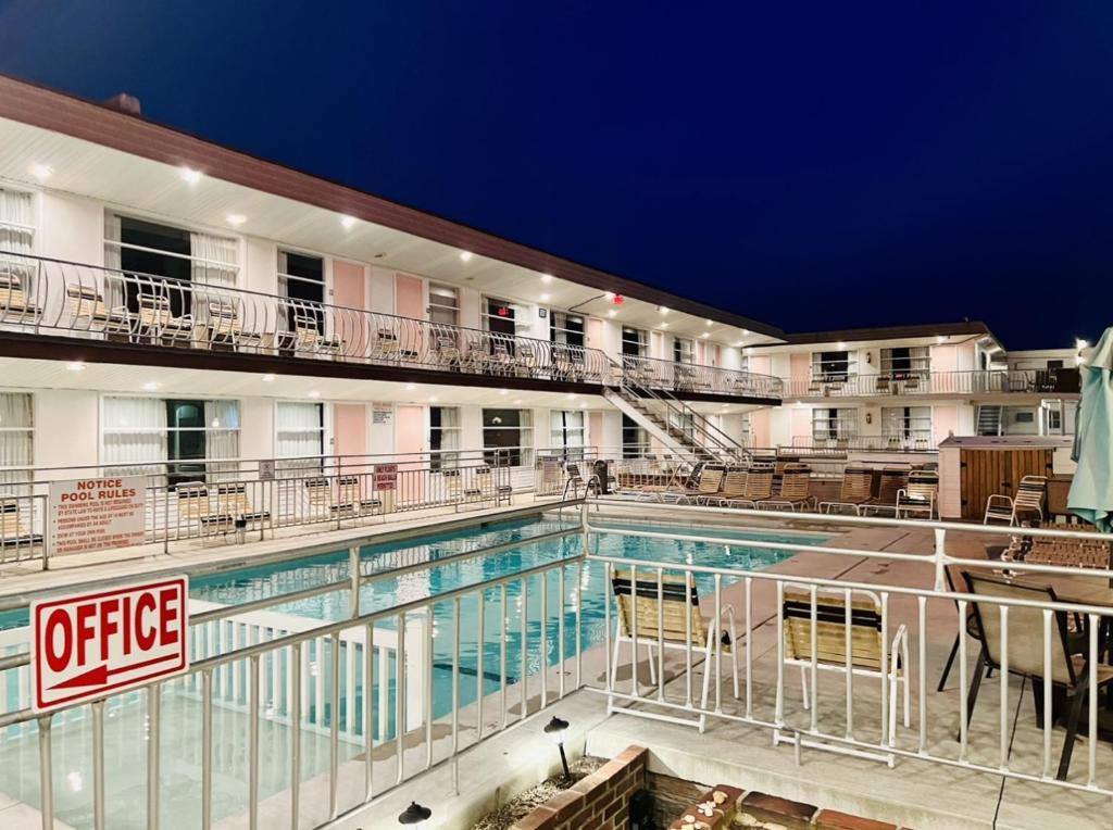 a hotel swimming pool with chairs and a hotel at Ivanhoe Motel in North Wildwood