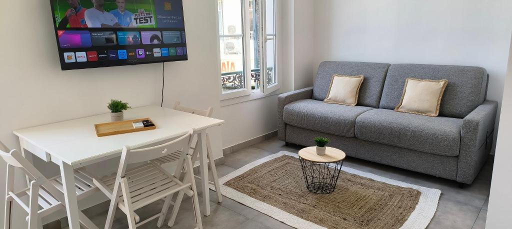 uma sala de estar com um sofá e uma mesa em PLEIN SUD - moderne studio avec mezzanine- Hyper centre Antibes - Proche port em Antibes