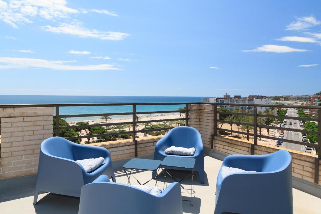 a balcony with chairs and a view of the beach at UHC CASPEL APARTMENTS in La Pineda