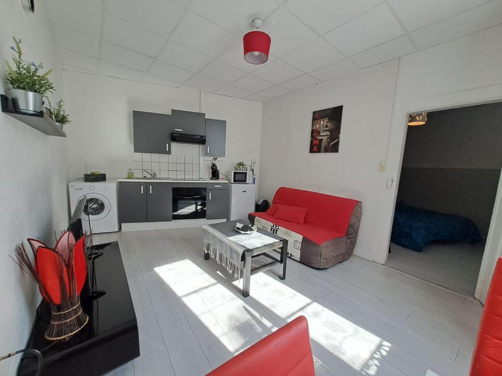 a living room with a red couch and a table at Appartement cosy sur Masevaux in Masevaux