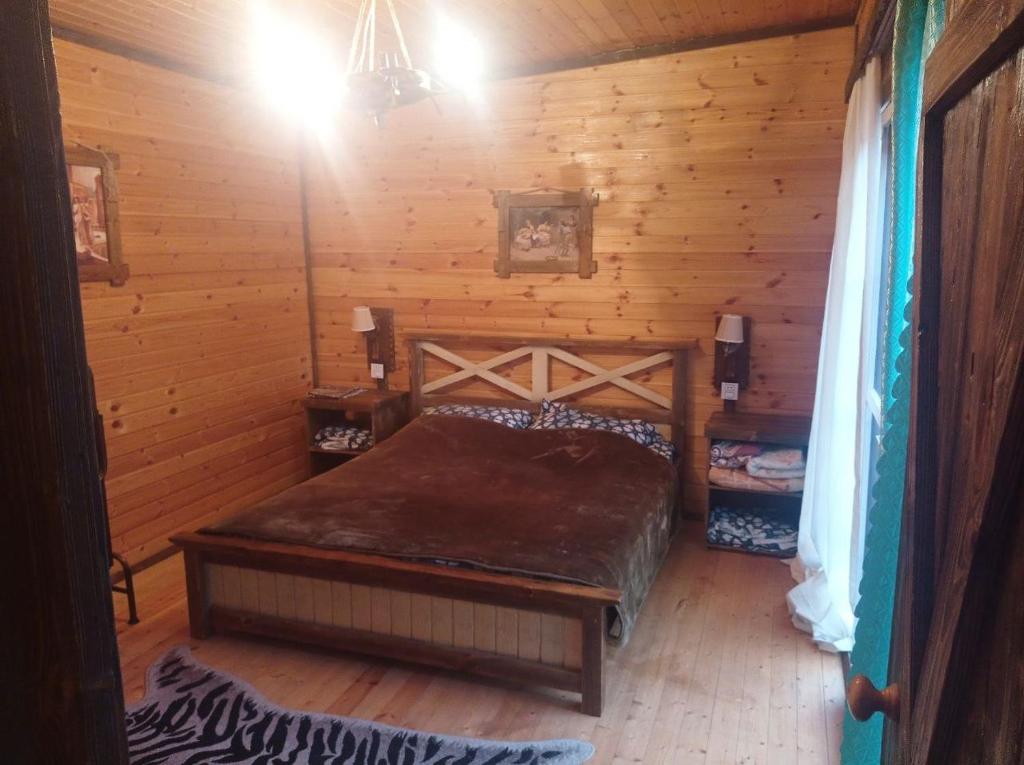1 dormitorio con 1 cama en una cabaña de madera en Fairytale Aframe House en Quba