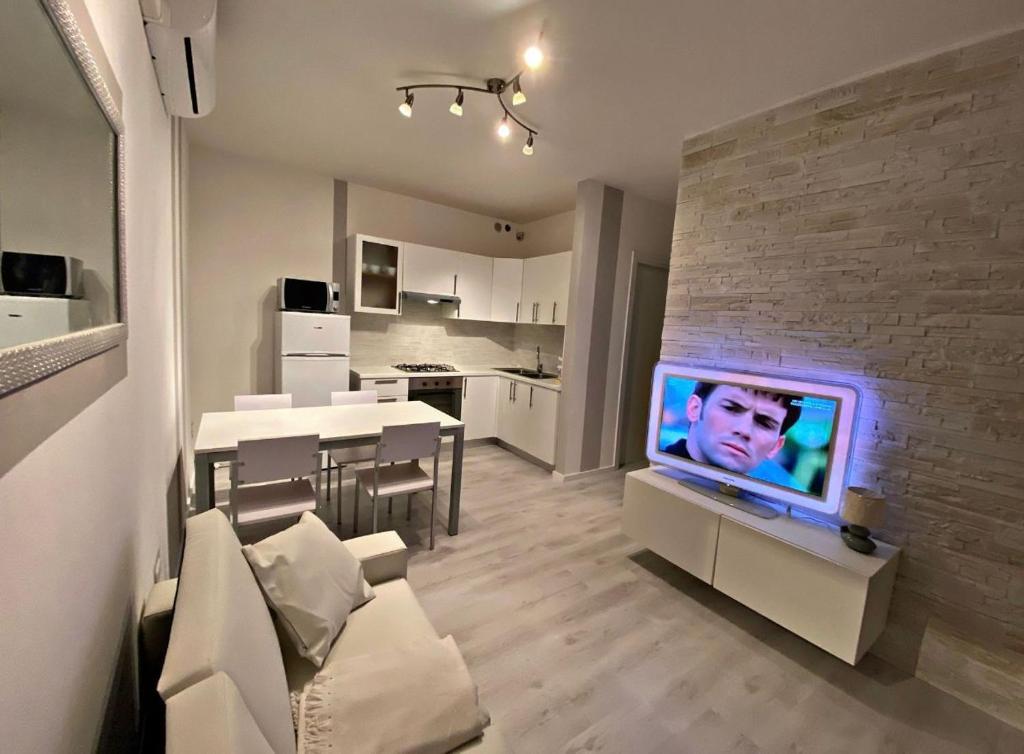 een woonkamer met een tv aan een bakstenen muur bij [SolMare] Apartments - Private parking - Pool in Rosapineta