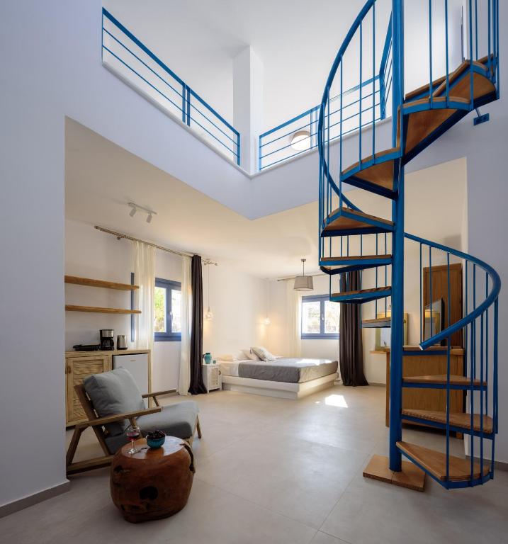 a living room with a spiral staircase and a bedroom at White Dream Suites Antiparos in Antiparos