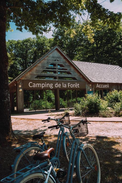 two bikes parked in front of a building at Camping de la Forêt Seasonova in Sillé-le-Guillaume