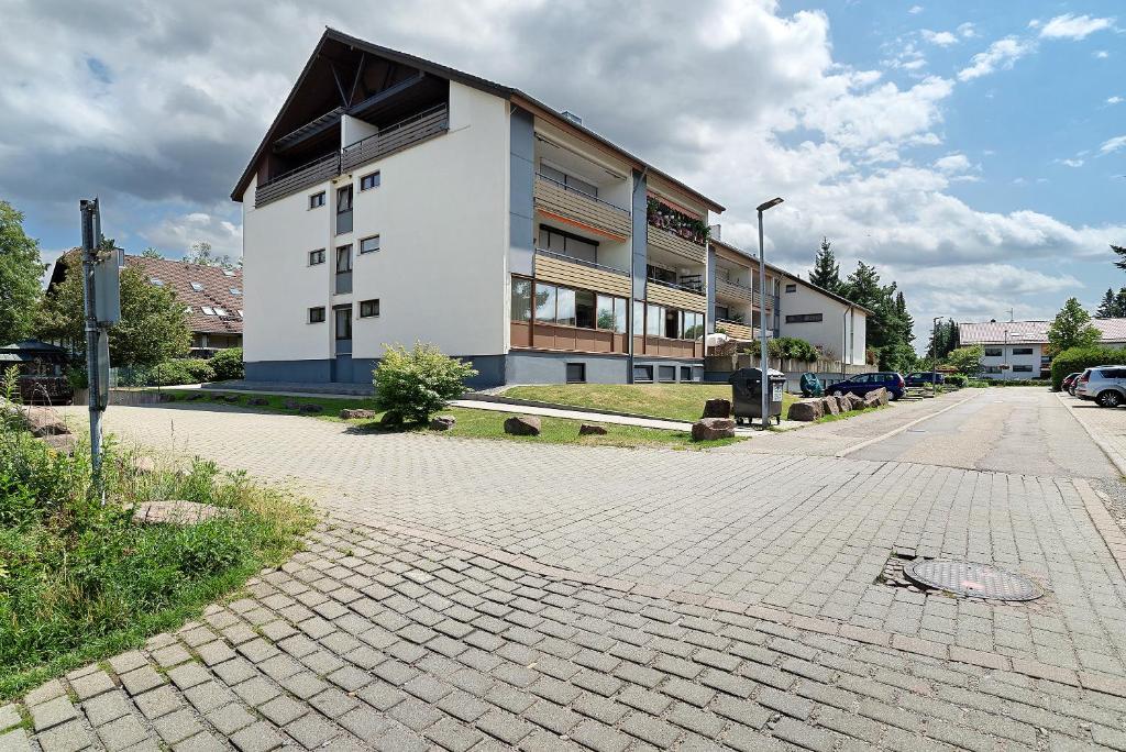 a white building with a black roof on a street at Appartement Arend in Dobel