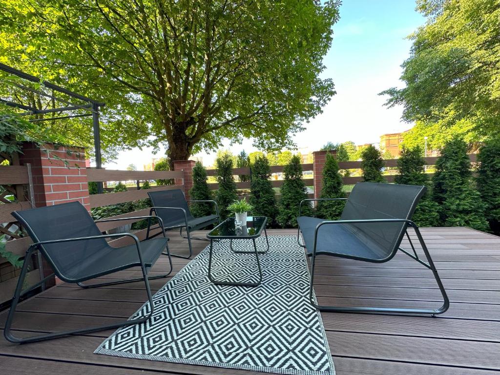 grupa krzeseł i stół na patio w obiekcie Lux Garden Apartment w Kołobrzegu