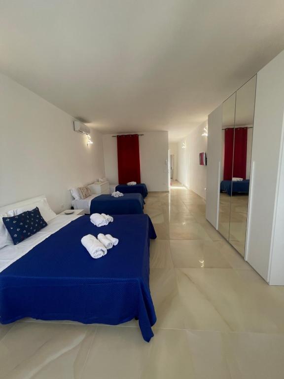 2 camas en una habitación con sábanas azules y toallas en Virgilio Street, en Borgagne