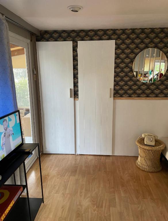 a living room with a white door and a mirror at Camping Oasis village in Puget-sur-Argens