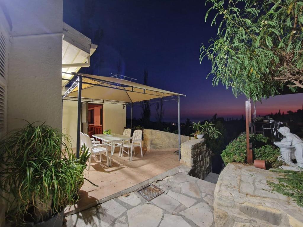 a house with a patio with a table and chairs at Cyprus style Stone Villa in Paphos City