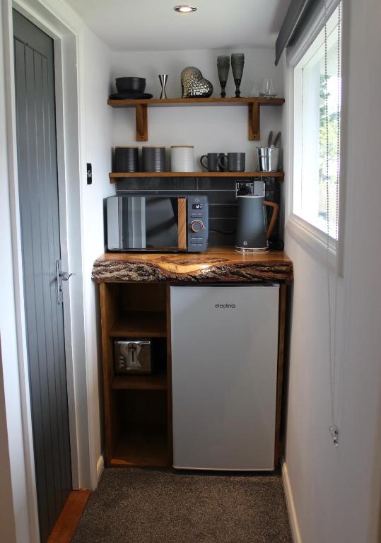 a small kitchen with a counter with a refrigerator at The Bubble Hideaway - A Little Oasis near the Sea in Whitstable